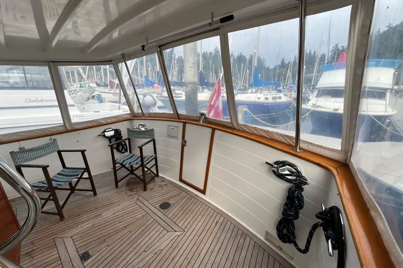 Abina Yacht Photos Pics Enclosed deck of 2001 Kadey-Krogen 39 yacht with chairs and marina view.