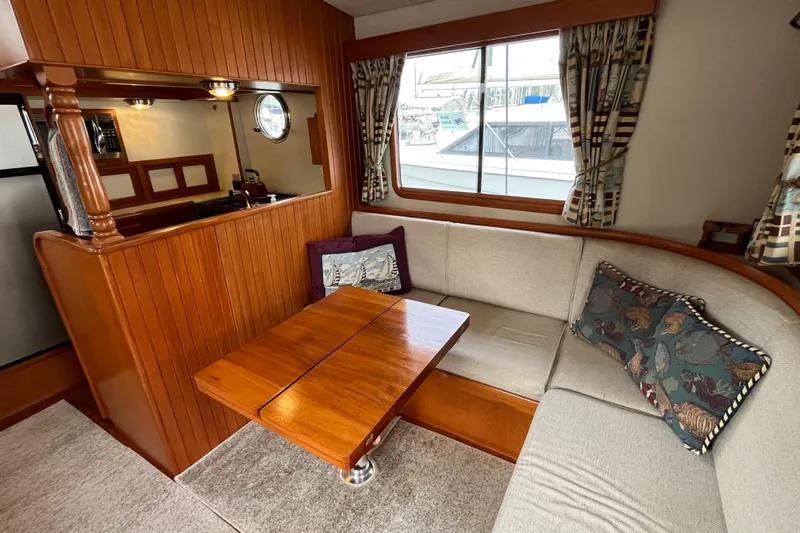 Abina Yacht Photos Pics Cozy interior of 2001 Kadey-Krogen 39 yacht with wooden table and cushioned seating.