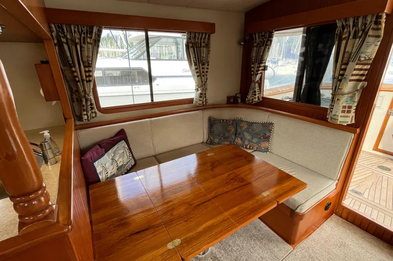 Abina Yacht Photos Pics Cozy dining area in 2001 Kadey-Krogen 39 yacht with wooden table and cushioned seating.