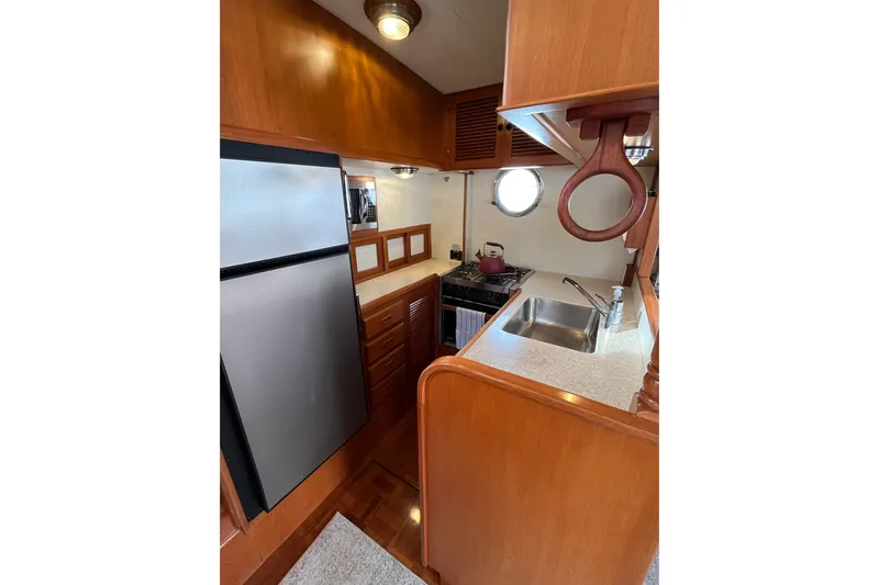 Abina Yacht Photos Pics 2001 Kadey-Krogen 39 yacht kitchen with stainless steel appliances and wooden cabinetry.
