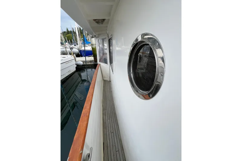 Abina Yacht Photos Pics Side deck of 2001 Kadey-Krogen 39 yacht with porthole and wooden railing.