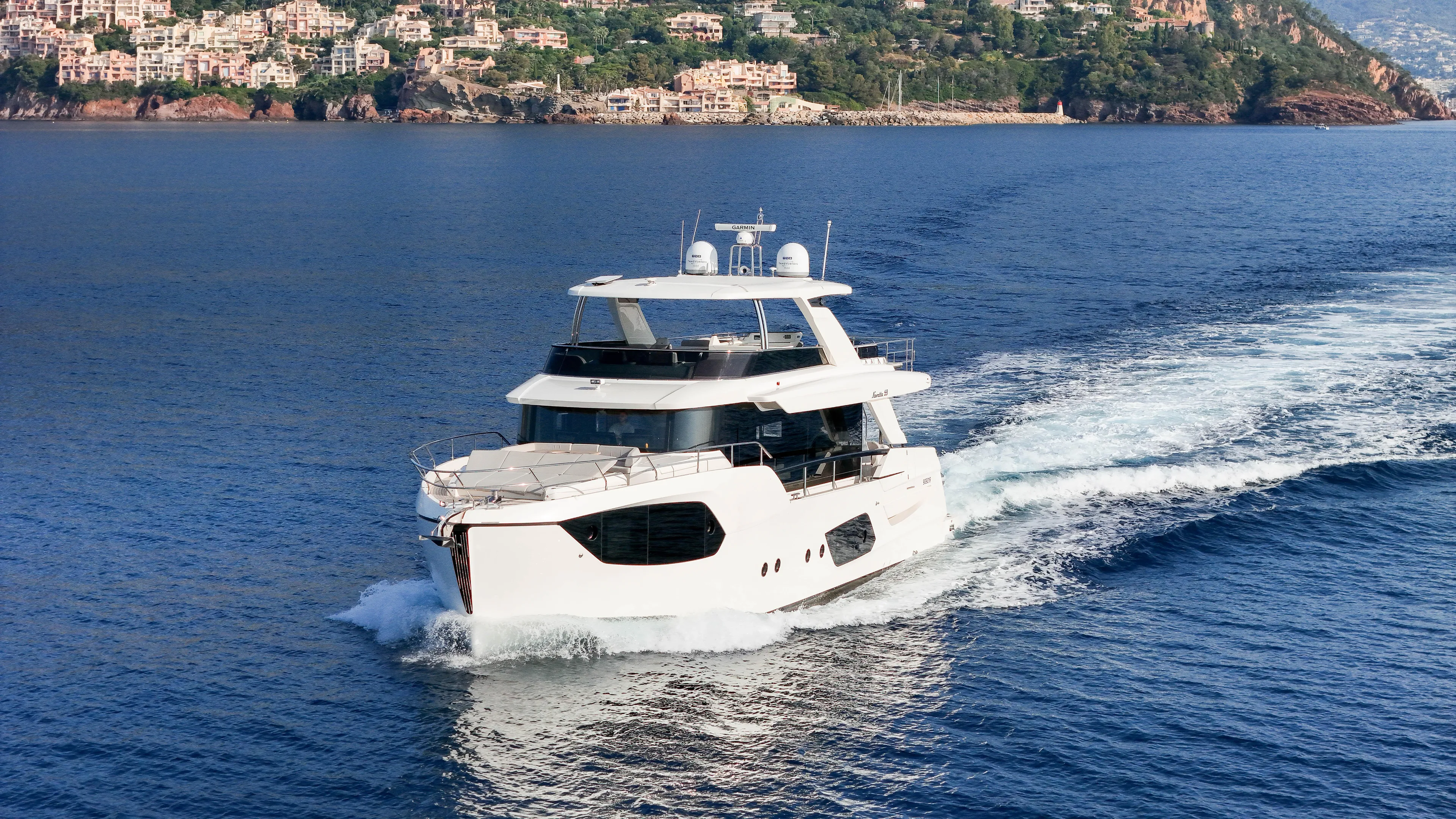  Yacht Photos Pics 2023 Absolute Navetta 68 yacht cruising on blue ocean near scenic coastline.