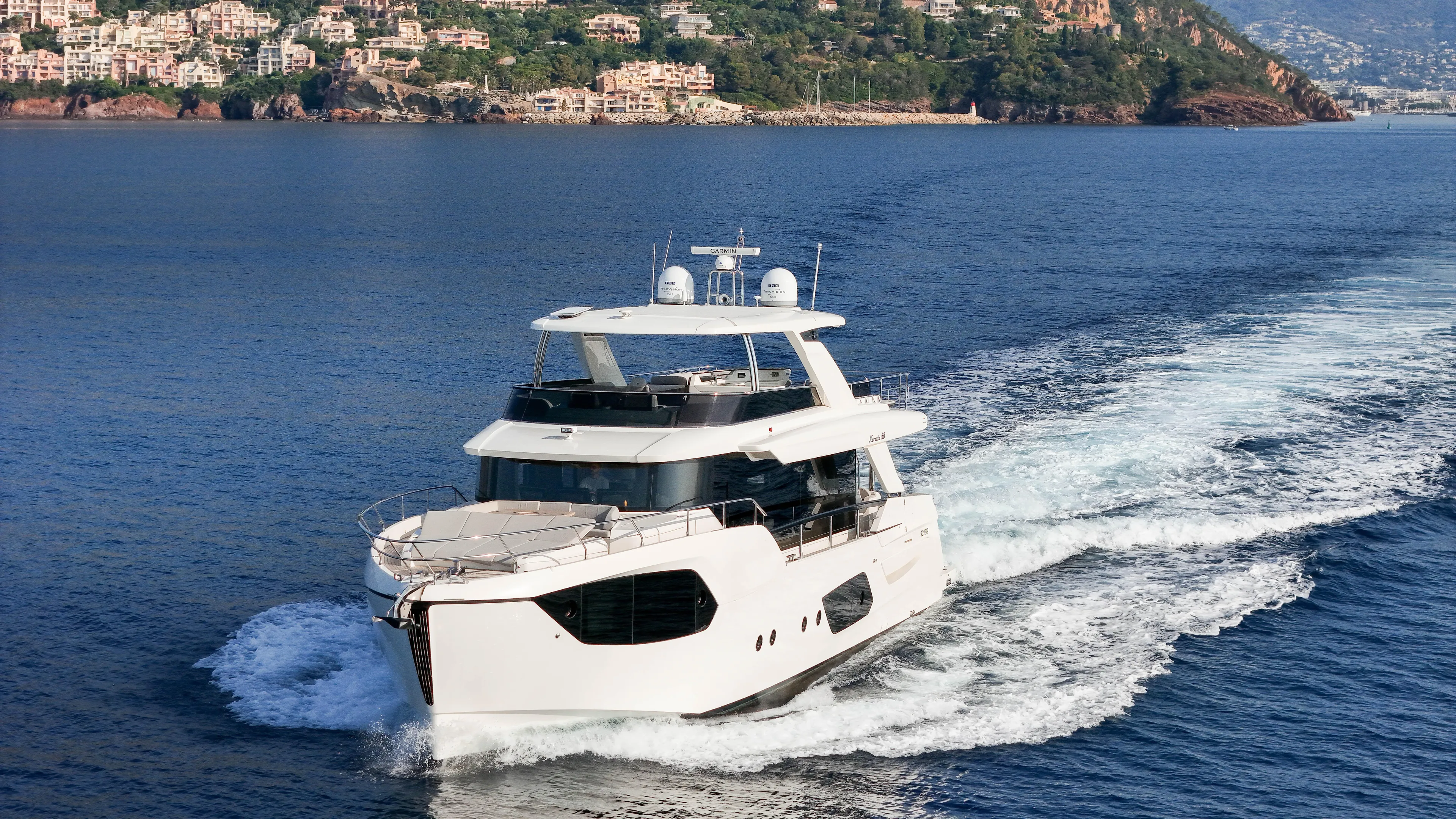  Yacht Photos Pics 2023 Absolute Navetta 68 yacht cruising on open water near coastal landscape.