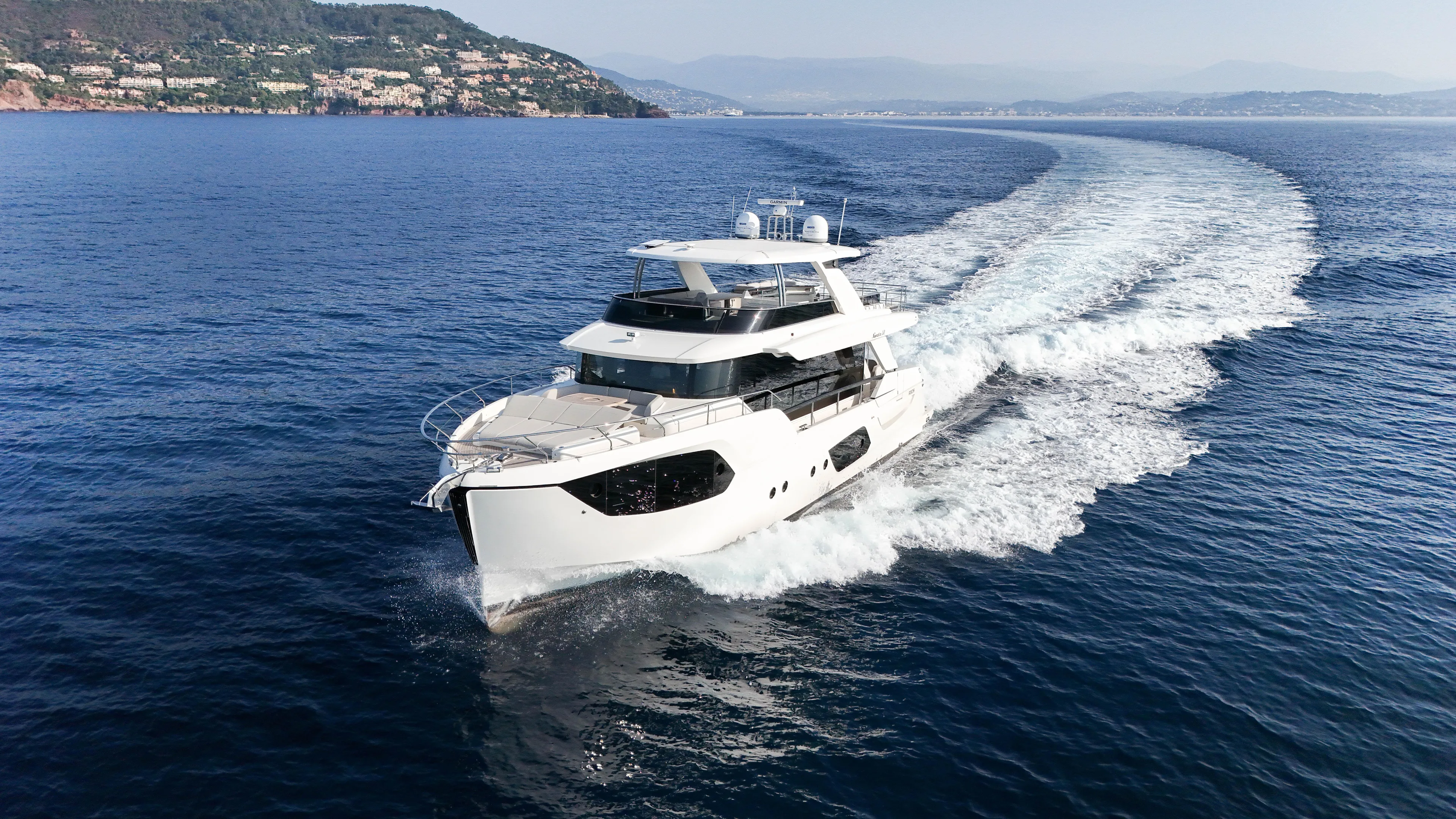  Yacht Photos Pics 2023 Absolute Navetta 68 yacht cruising on open sea with scenic coastal backdrop.