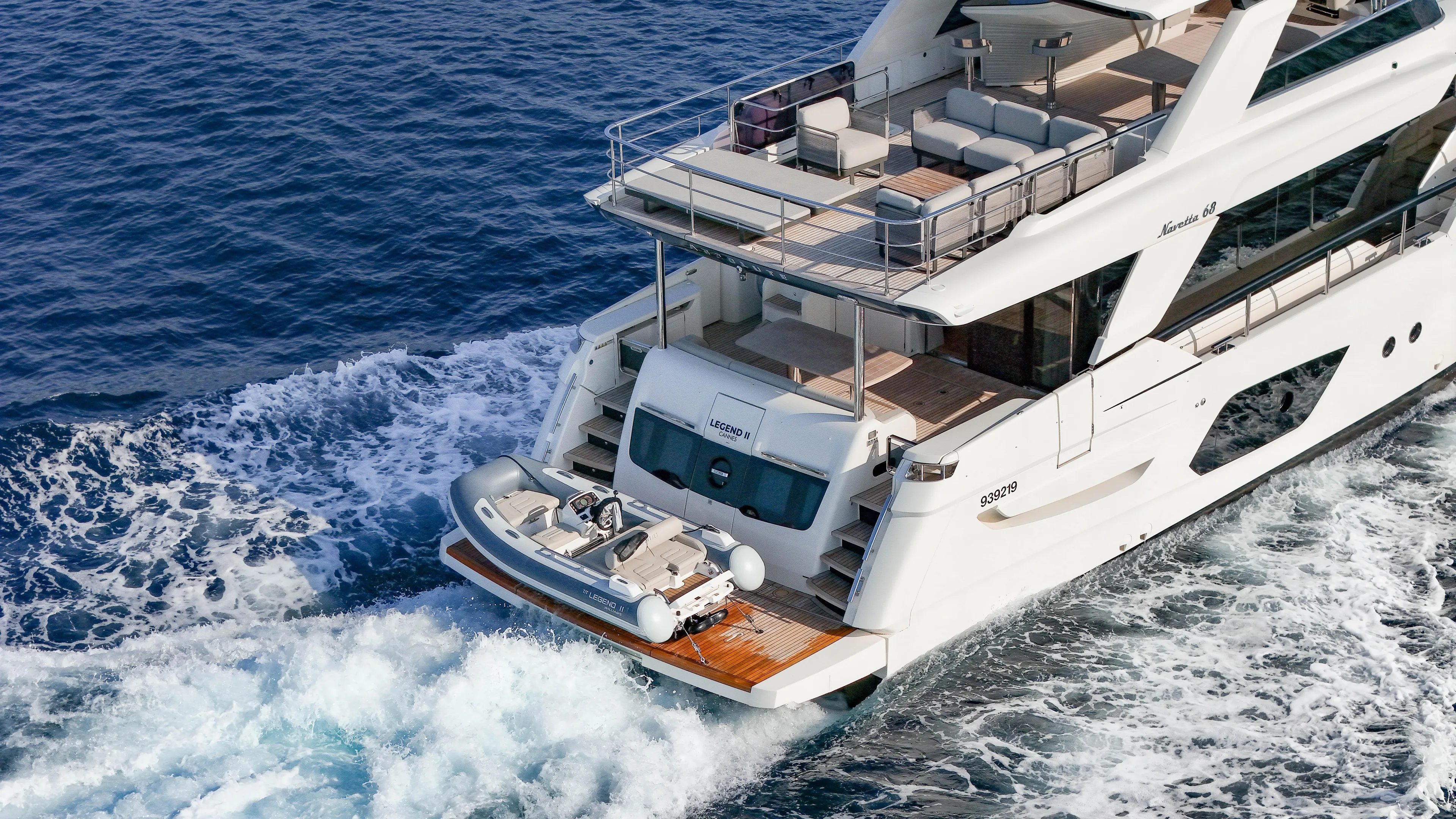  Yacht Photos Pics Luxury 2023 Absolute Navetta 68 yacht cruising on open sea, featuring spacious deck and tender.