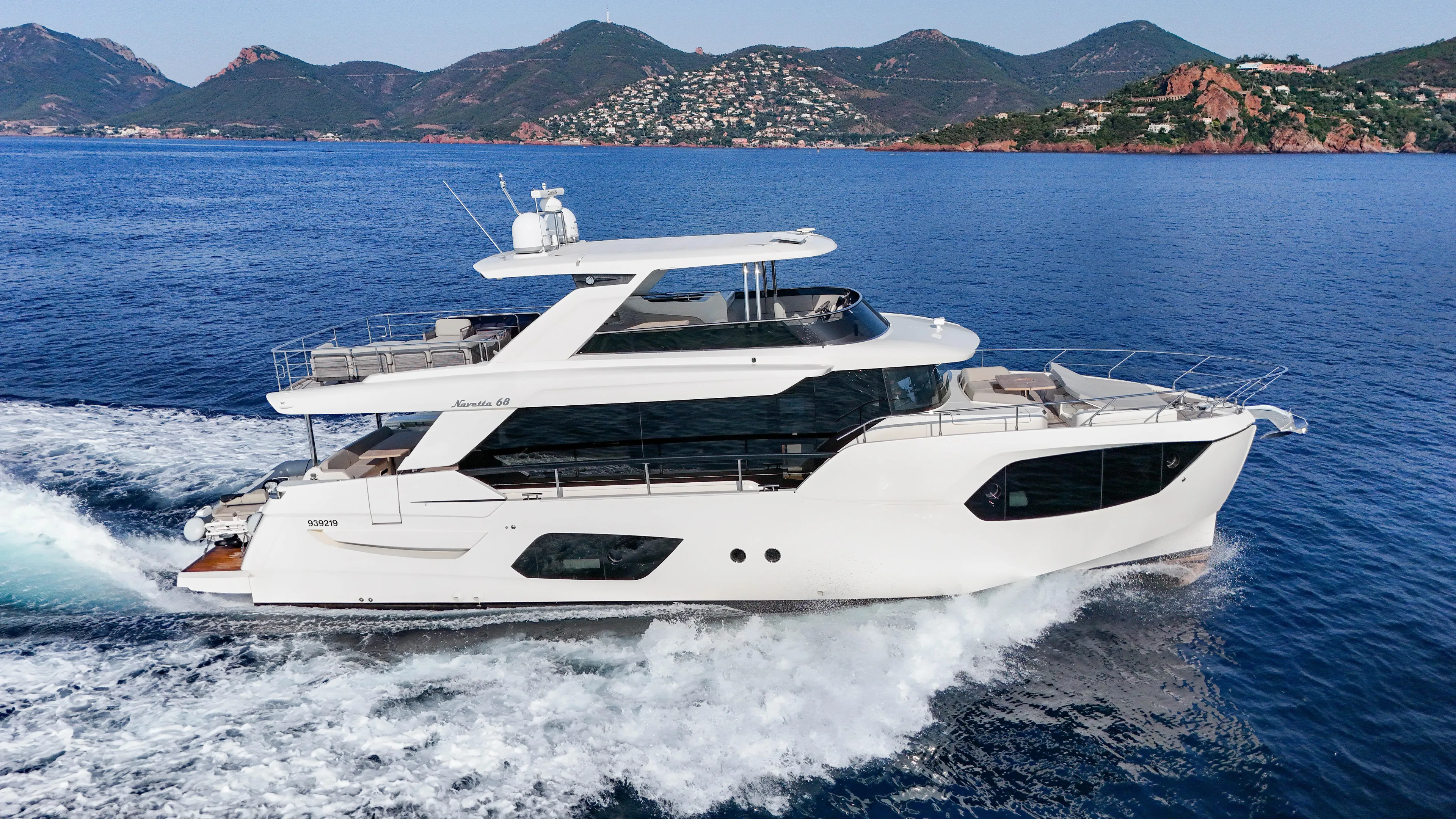  Yacht Photos Pics 2023 Absolute Navetta 68 yacht cruising on blue ocean with scenic mountain backdrop.