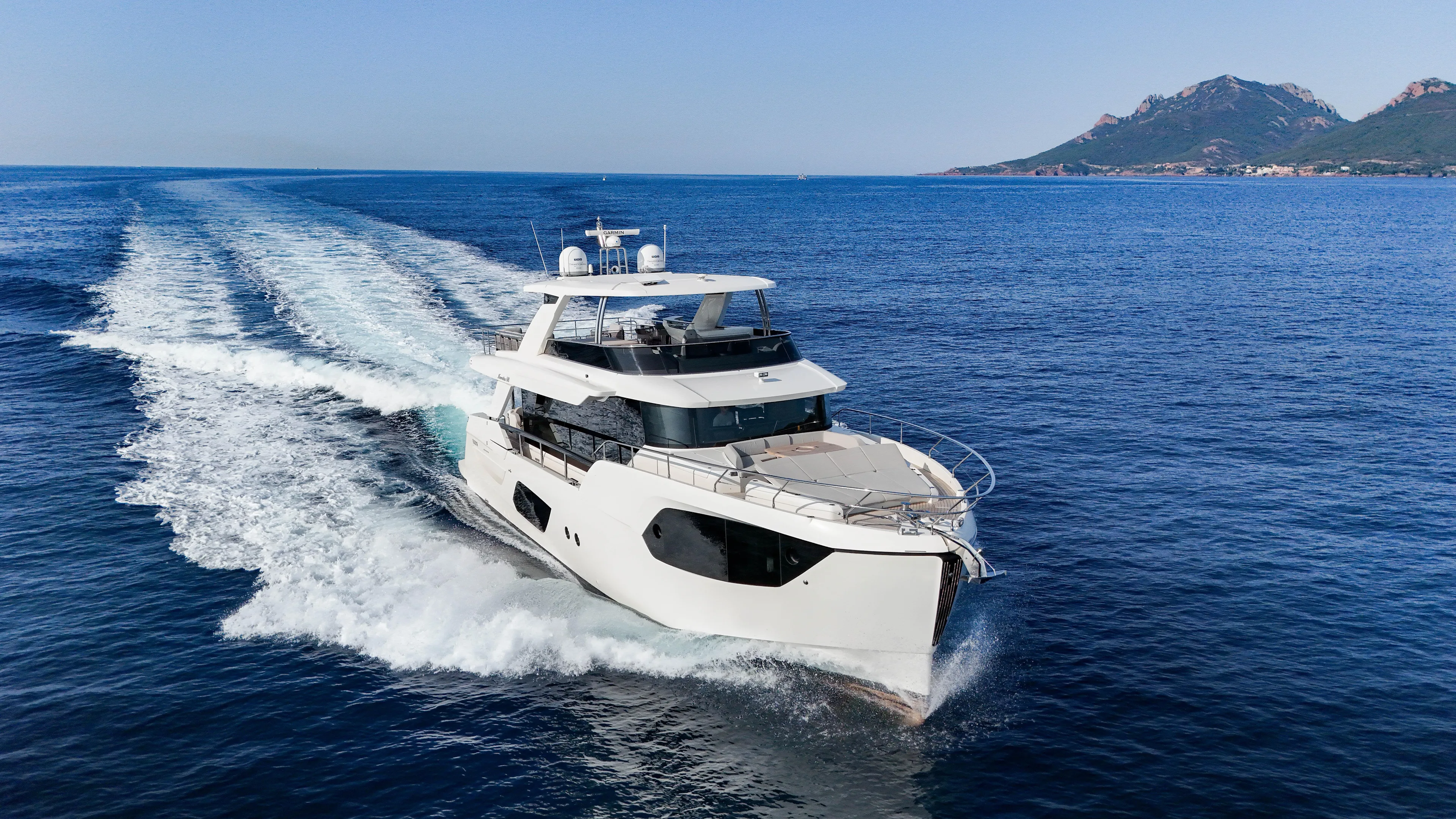  Yacht Photos Pics 2023 Absolute Navetta 68 yacht cruising on open sea with scenic mountain backdrop.