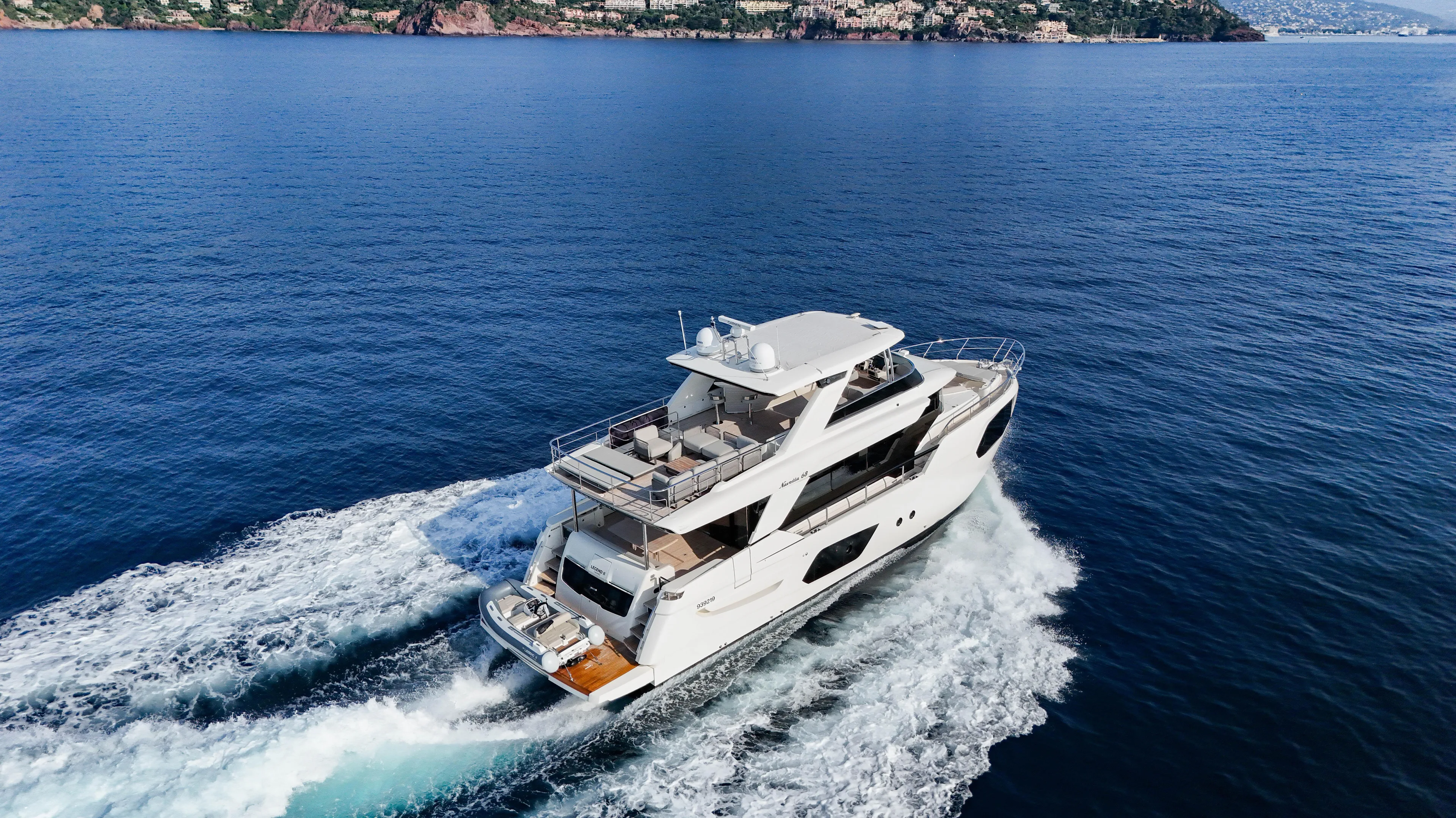  Yacht Photos Pics 2023 Absolute Navetta 68 yacht cruising on open sea with scenic coastal backdrop.