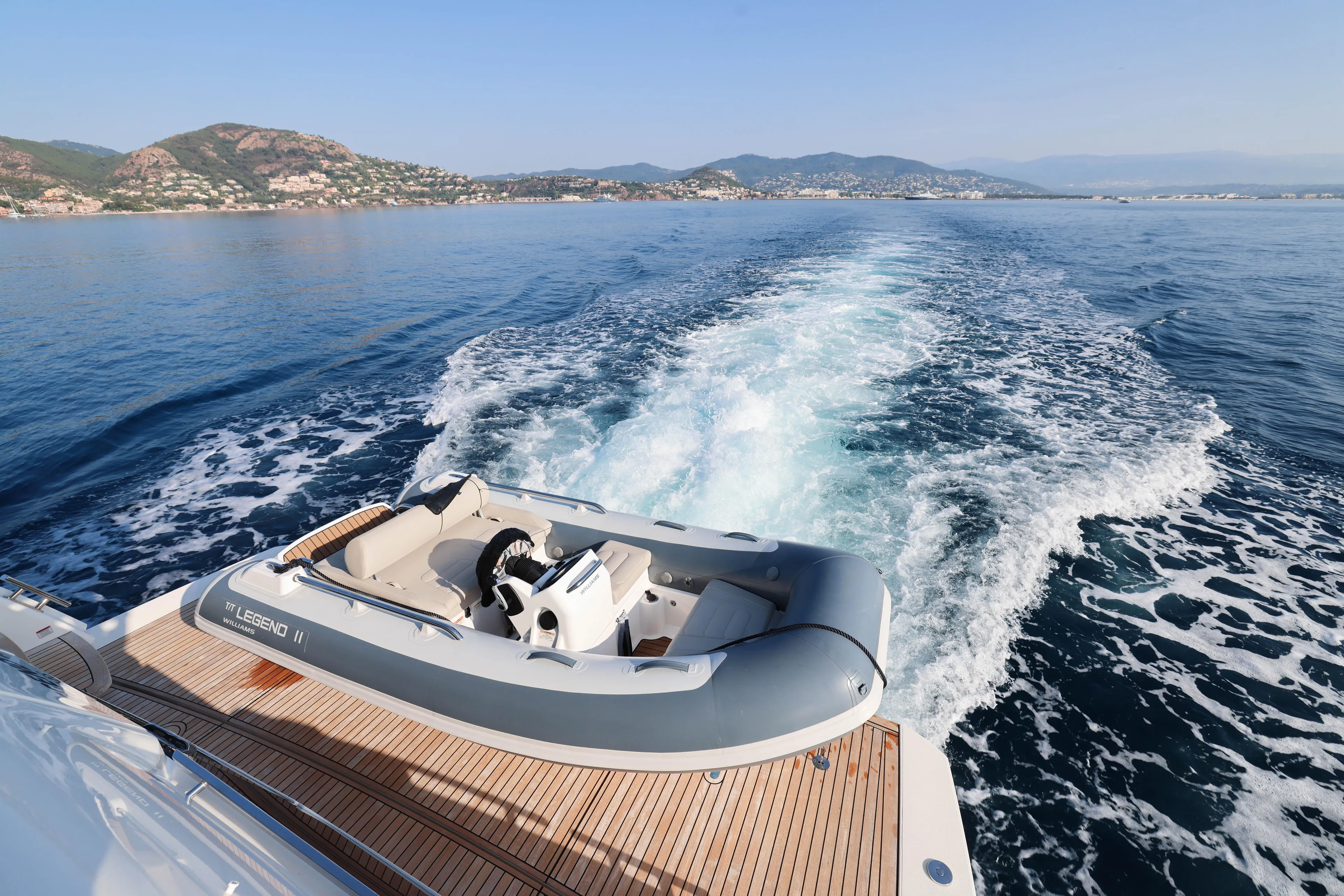  Yacht Photos Pics 2023 Absolute Navetta 68 yacht with tender on deck, cruising in scenic coastal waters.