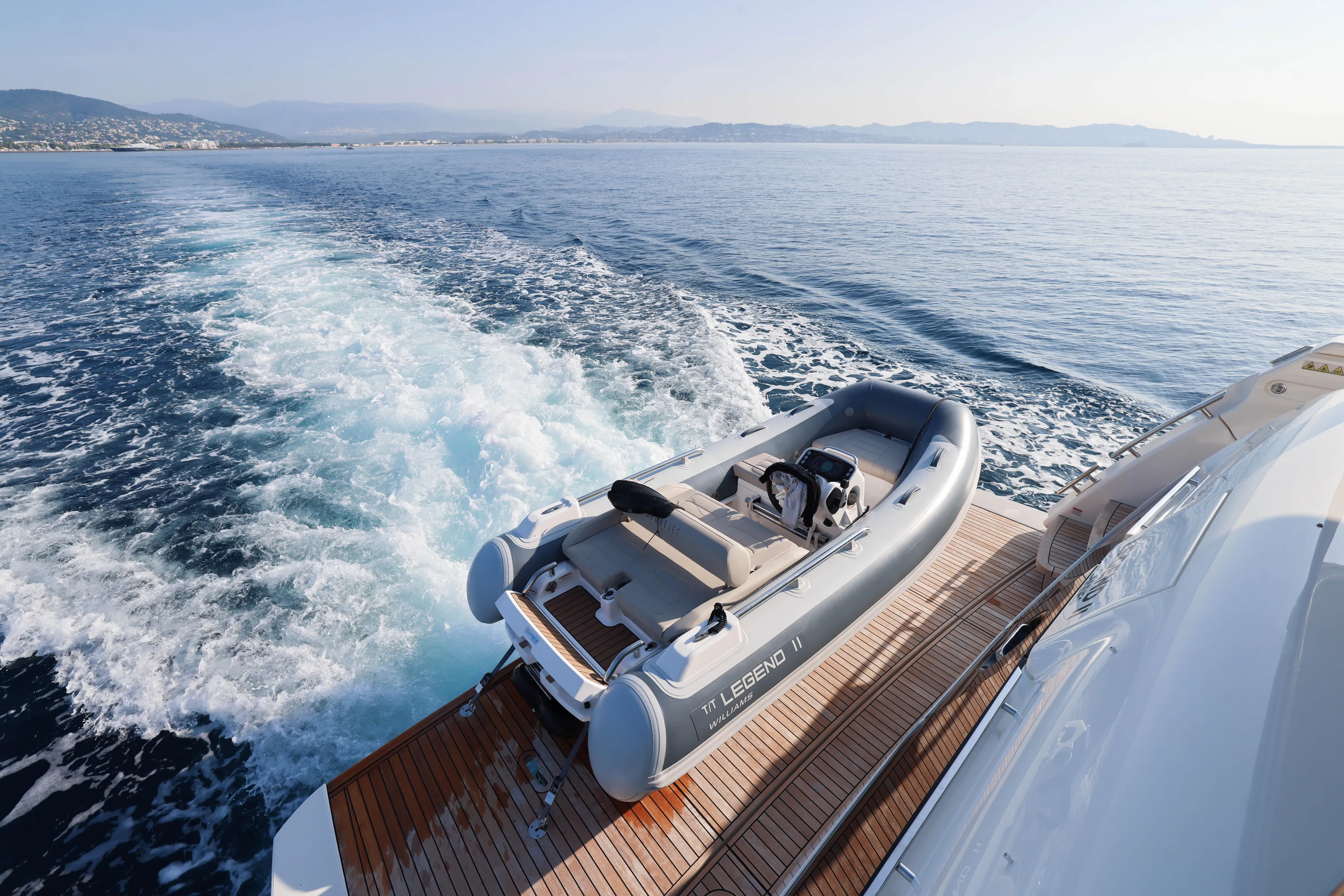  Yacht Photos Pics 2023 Absolute Navetta 68 yacht with tender on wooden deck, cruising in open sea.