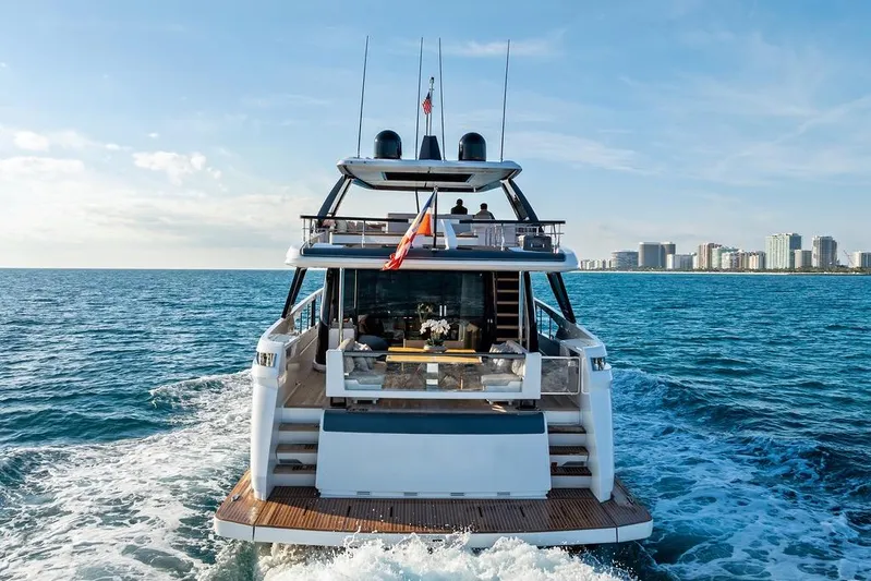  Yacht Photos Pics 2023 Ferretti Yachts 860 cruising on open sea with city skyline backdrop.