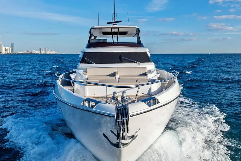  Yacht Photos Pics 2023 Ferretti Yachts 860 cruising on open sea with city skyline in background.