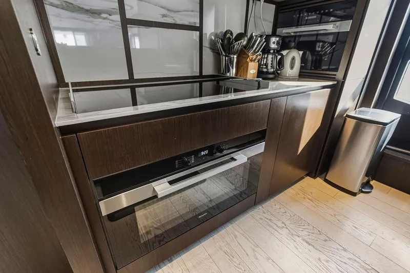  Yacht Photos Pics Modern kitchen interior on 2023 Ferretti Yachts 860, featuring sleek appliances and wooden cabinetry.