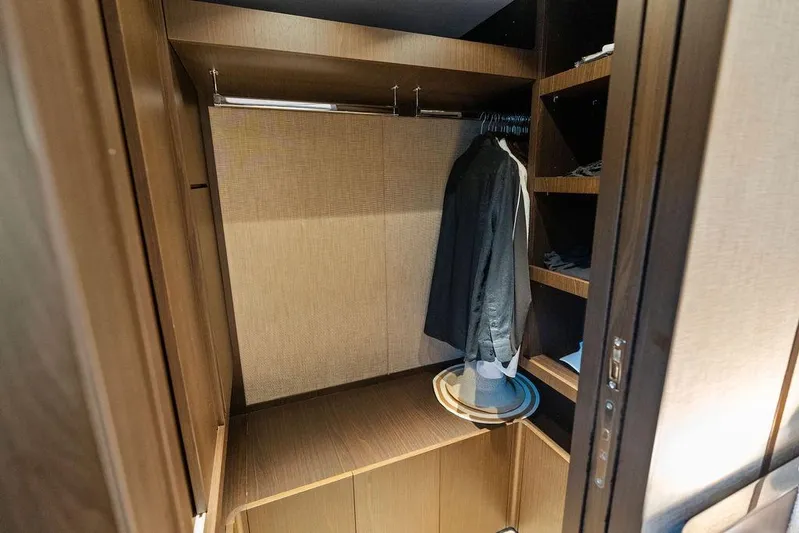  Yacht Photos Pics Luxurious wooden closet interior on 2023 Ferretti Yachts 860, featuring hanging space and shelves.