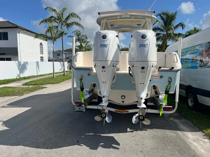  Yacht Photos Pics 2022 Grady-White Freedom 275 boat with dual 200 horsepower engines, parked on a sunny street.