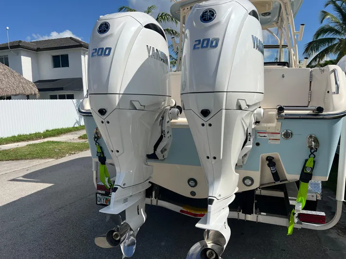  Yacht Photos Pics 2022 Grady-White Freedom 275 with twin Yamaha 200 engines, parked near a house.