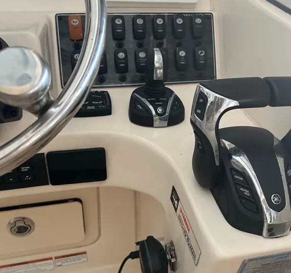  Yacht Photos Pics Control panel of 2022 Grady-White Freedom 275 boat with steering wheel and throttle controls.