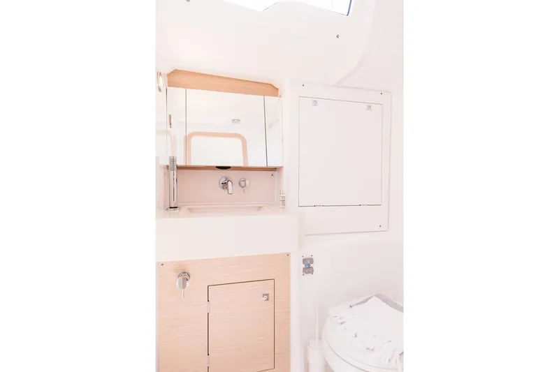  Yacht Photos Pics 2024 Dufour 37 yacht bathroom with modern fixtures and light wood cabinetry.