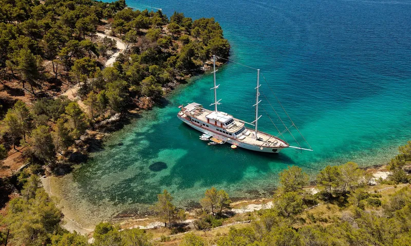 Corsario Yacht Photos Pics Aerial view of 2019 Custom RADEŽ d.d. Schooner anchored in a turquoise bay.