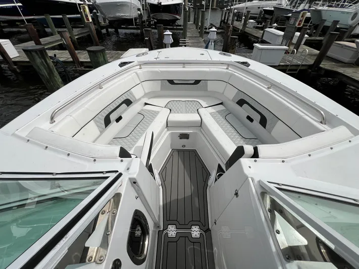 Blackfin Yacht Photos Pics 2023 Blackfin 272DC boat interior with spacious seating at a marina.