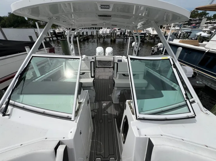 Blackfin Yacht Photos Pics 2023 Blackfin 272DC boat with open cockpit and modern design at a marina.