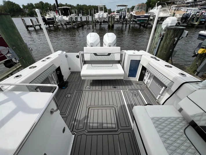 Blackfin Yacht Photos Pics 2023 Blackfin 272DC boat interior with seating, docked at marina.