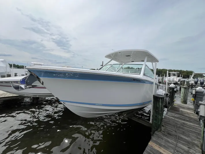 Blackfin Yacht Photos Pics 2023 Blackfin 272DC boat docked at a marina under a cloudy sky.