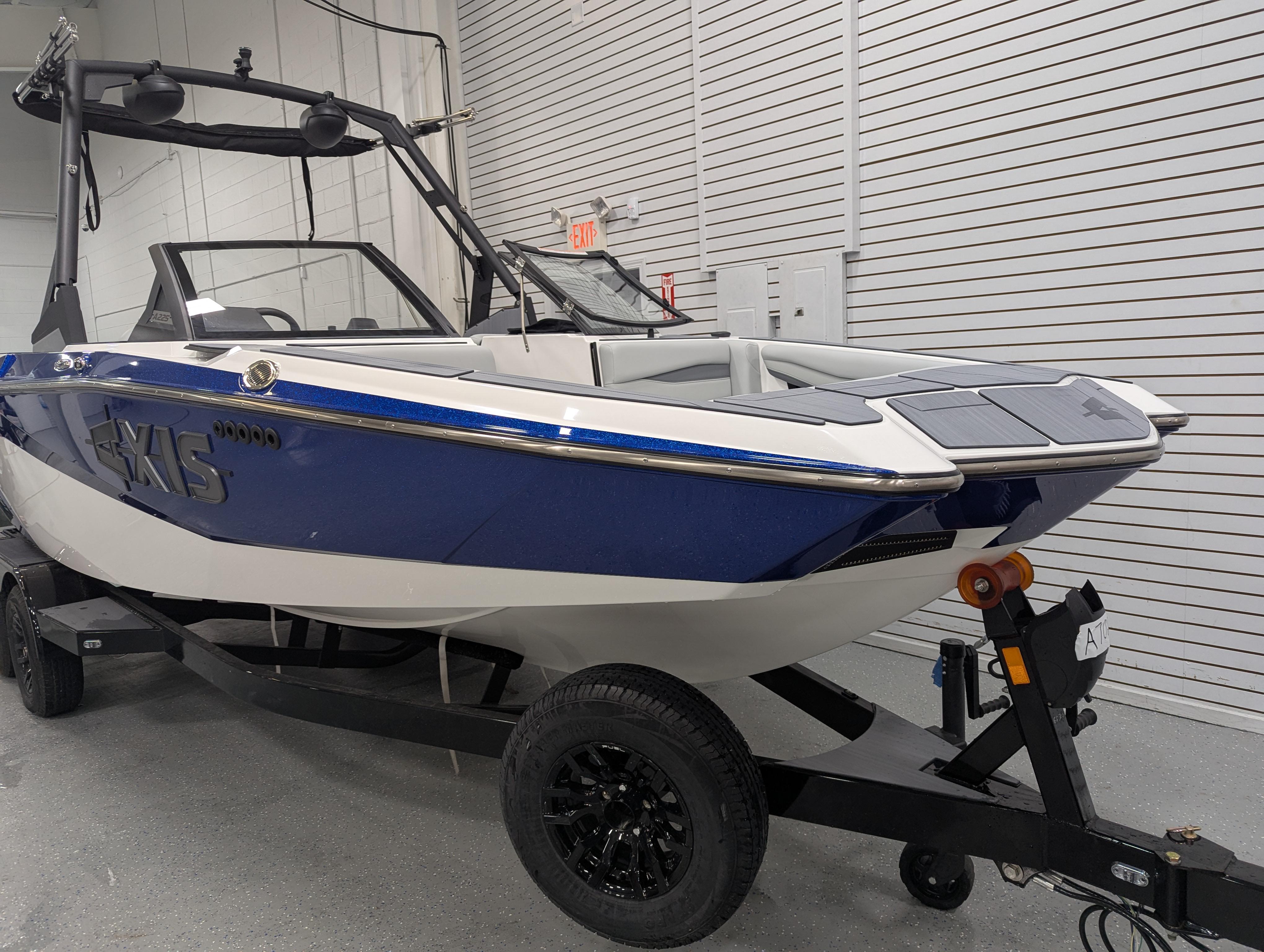 2025 Axis A225 boat in a showroom, featuring a sleek blue and white design.