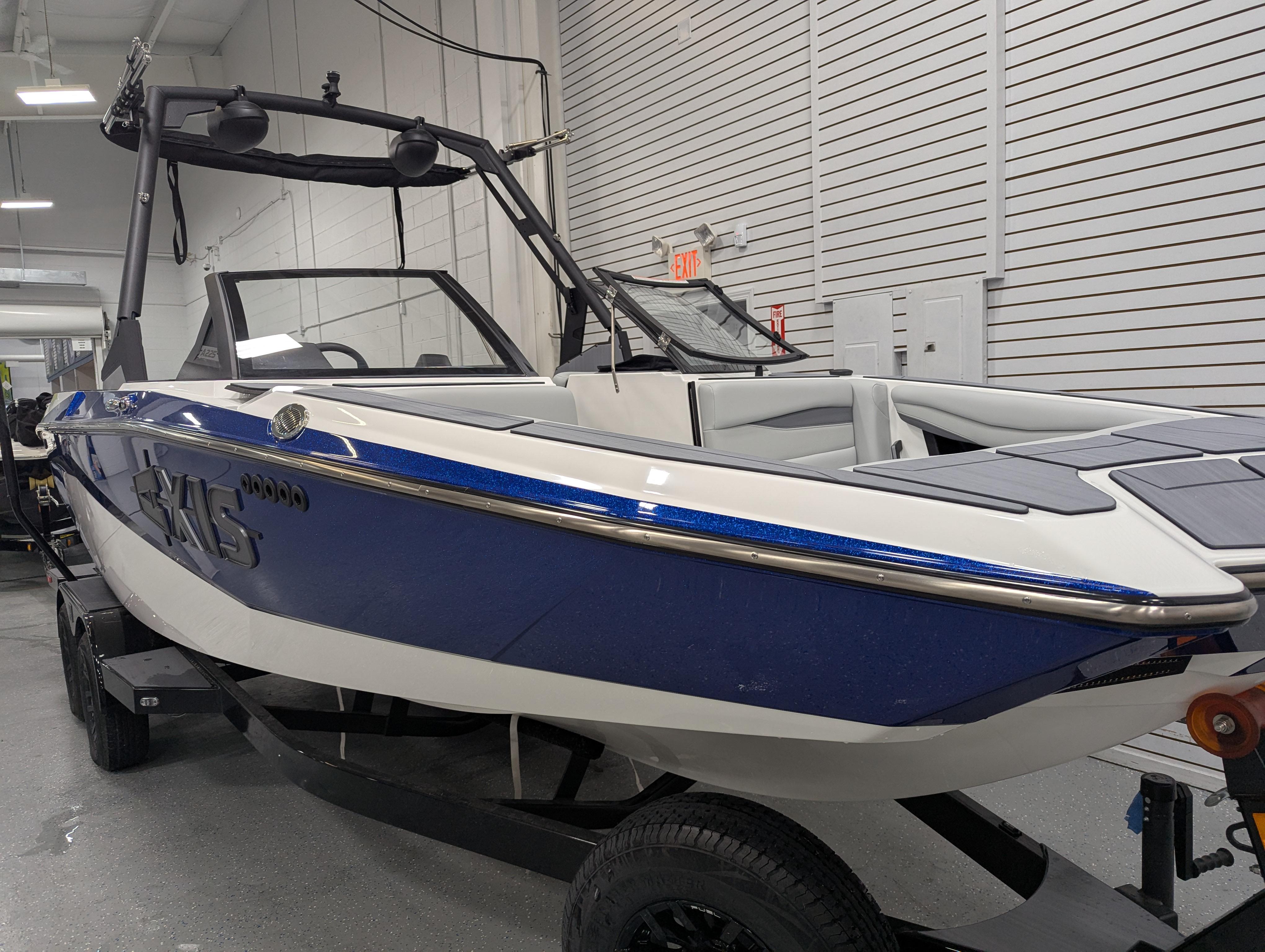 2025 Axis A225 boat in showroom, blue and white design, on trailer.