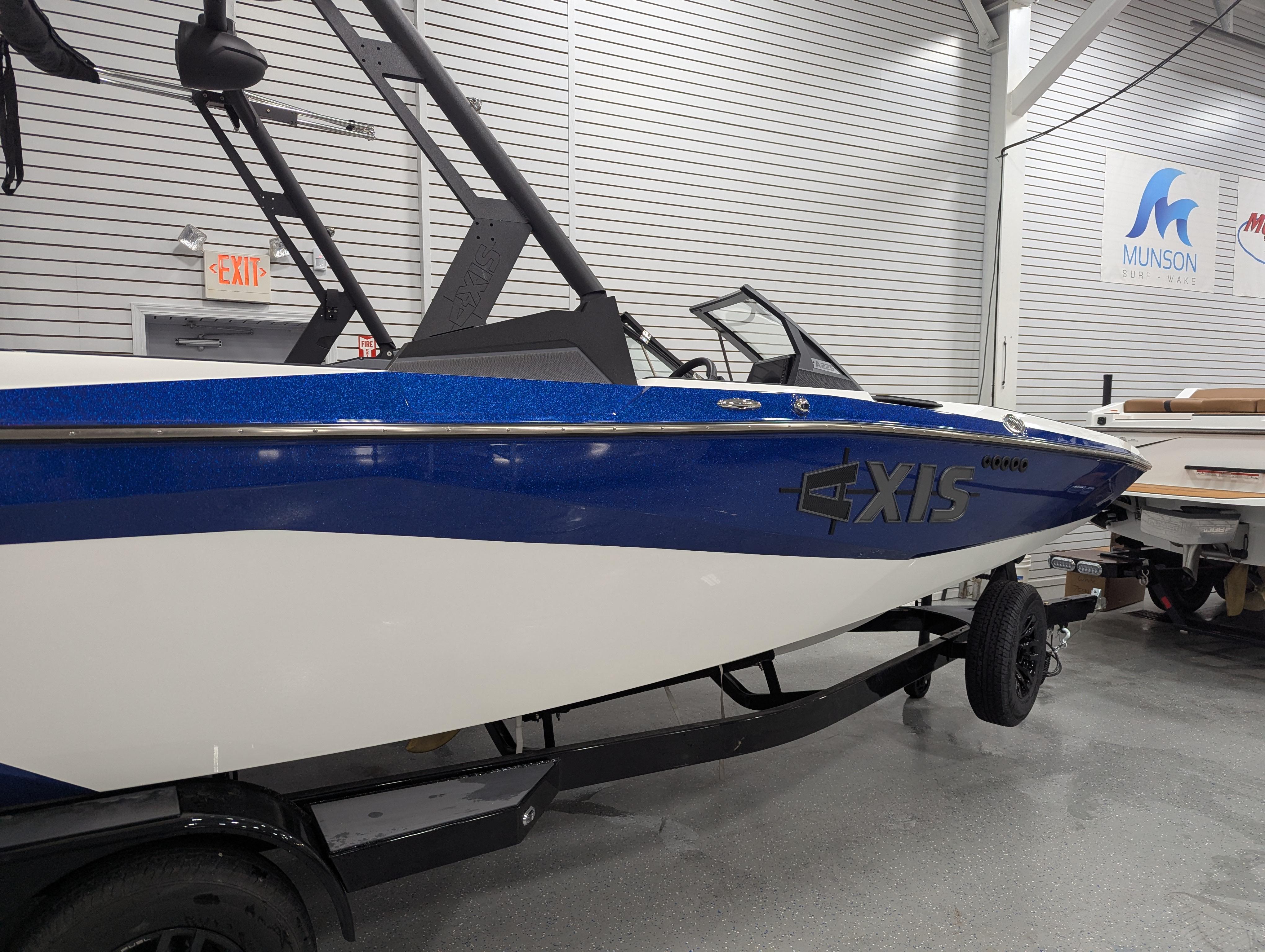 2025 Axis A225 boat in showroom, blue and white design, on trailer.