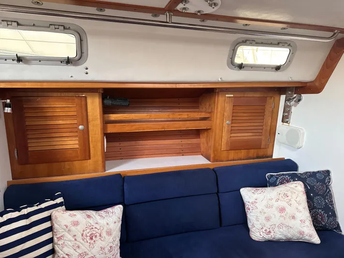 Valcor II Yacht Photos Pics Interior of 1996 J Boats J/42 with wooden cabinets and blue cushioned seating.