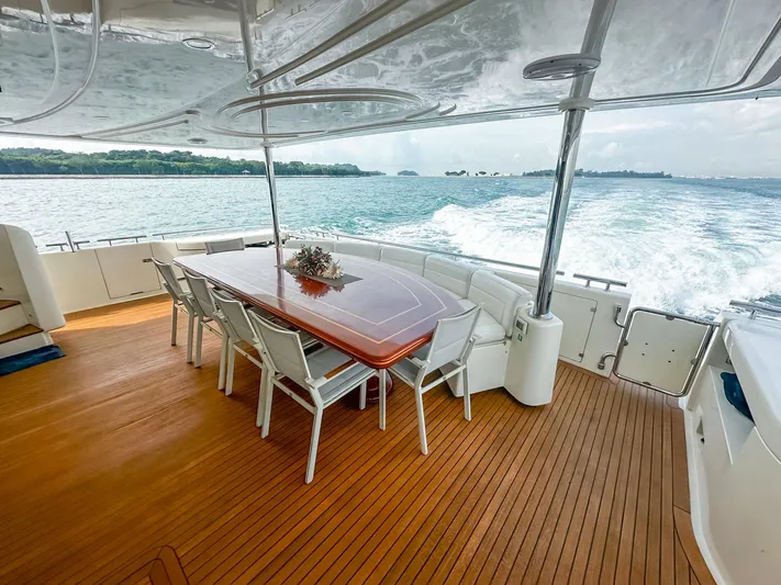 Eaglewings 3 Yacht Photos Pics Luxurious Custom Line 112 yacht deck with dining area, cruising on open water, 2005 model.