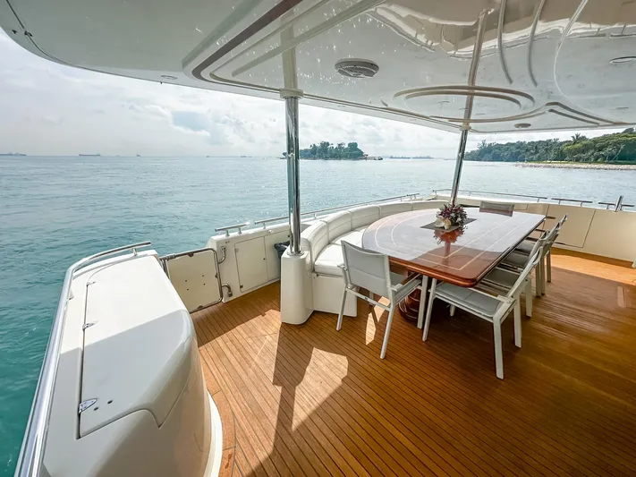 Eaglewings 3 Yacht Photos Pics Luxurious 2005 Custom Line 112 yacht deck with dining area overlooking serene ocean view.