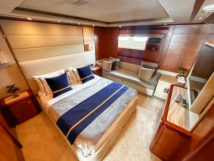 Eaglewings 3 Yacht Photos Pics Luxurious yacht bedroom with elegant decor, featuring a plush bed and cozy seating area. Custom Line 112, 2005.