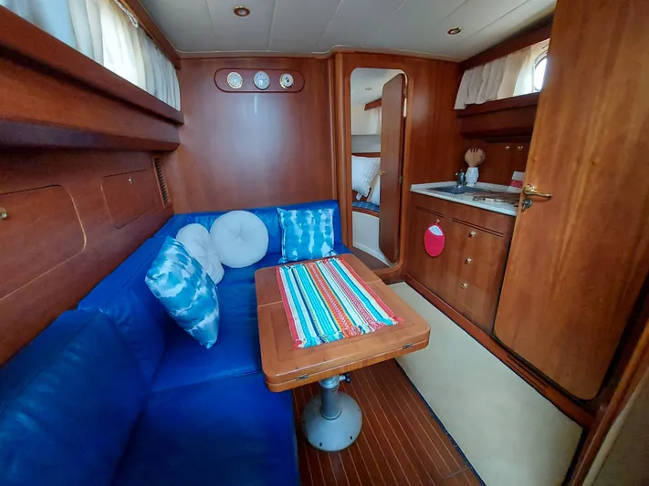 No Name Yacht Photos Pics Interior of 2001 Apreamare 10M Cabinato with blue seating and wooden finishes.