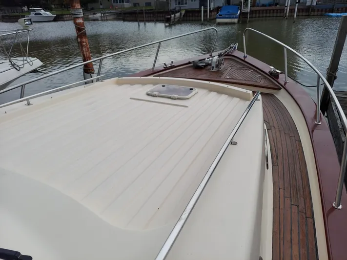 No Name Yacht Photos Pics 2001 Apreamare 10M Cabinato yacht deck with wooden accents, docked by the water.