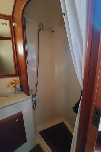 No Name Yacht Photos Pics Shower area in 2001 Apreamare 10M Cabinato yacht, featuring a curtain and wooden accents.