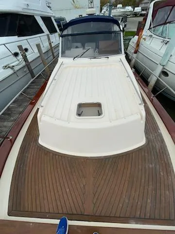 No Name Yacht Photos Pics Apreamare 10M Cabinato 2001 boat with wooden deck, docked alongside other vessels.