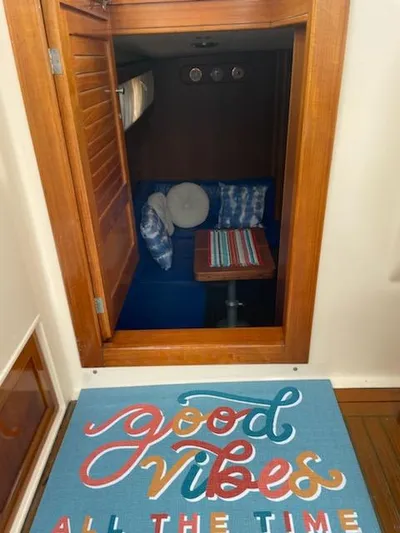 No Name Yacht Photos Pics 2001 Apreamare 10M Cabinato interior with cozy seating and "Good Vibes All The Time" mat.