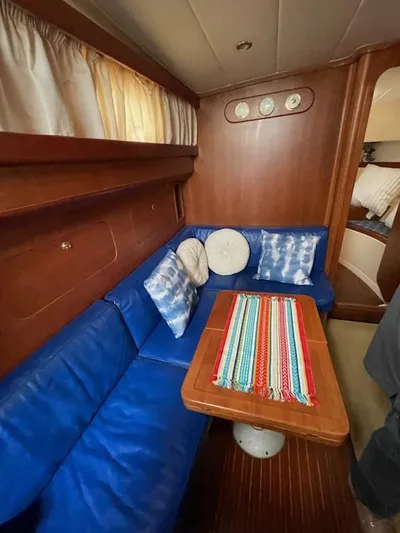 No Name Yacht Photos Pics Interior of 2001 Apreamare 10M Cabinato with blue seating and colorful table runner.