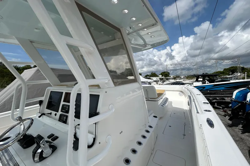 Trailer Included Yacht Photos Pics 2019 Invincible 40 Catamaran with modern helm, sleek design, and spacious deck under a cloudy sky.