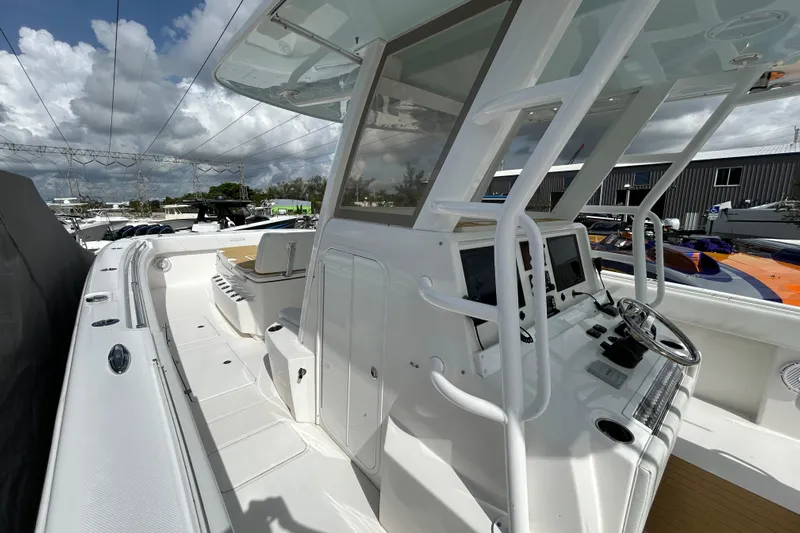Trailer Included Yacht Photos Pics 2019 Invincible 40 Catamaran cockpit with modern controls and seating under a cloudy sky.