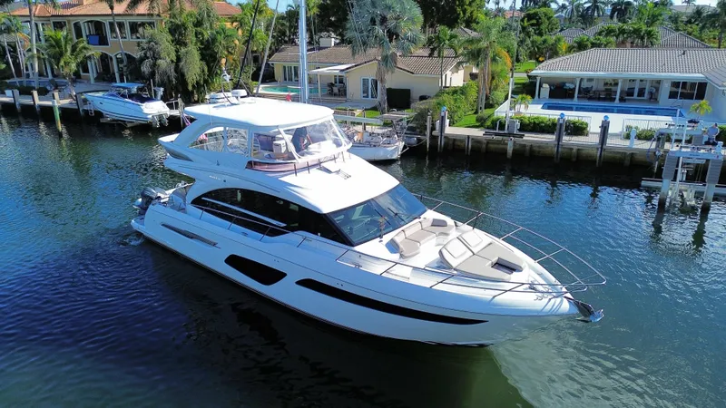  Yacht Photos Pics Luxurious 2019 Princess F62 yacht cruising near waterfront homes.