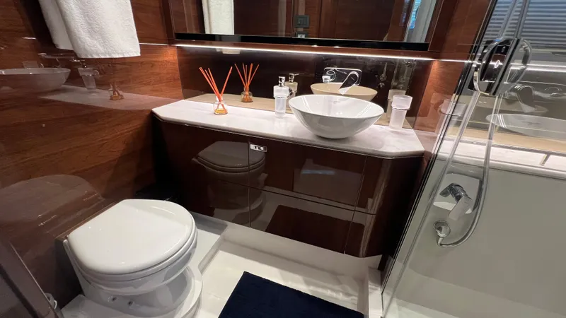  Yacht Photos Pics Luxurious bathroom in 2019 Princess F62 yacht with modern fixtures and elegant wood finish.