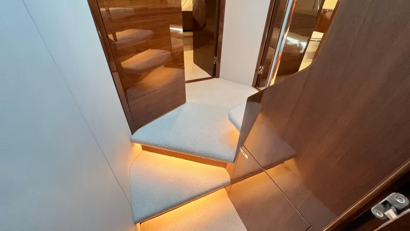  Yacht Photos Pics Luxurious interior staircase of 2019 Princess F62 yacht with elegant lighting.