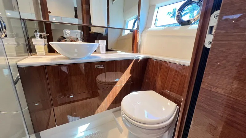  Yacht Photos Pics Luxurious bathroom in 2019 Princess F62 yacht with modern fixtures and wooden cabinetry.