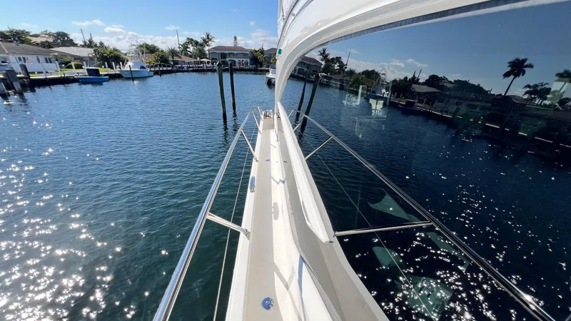  Yacht Photos Pics Luxurious 2019 Princess F62 yacht on sparkling water, reflecting a sunny marina view.