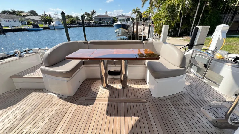  Yacht Photos Pics Luxurious 2019 Princess F62 yacht deck with elegant seating and wooden table by the water.