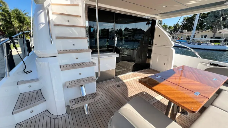  Yacht Photos Pics Luxurious 2019 Princess F62 yacht interior with wooden table and staircase, docked by the water.