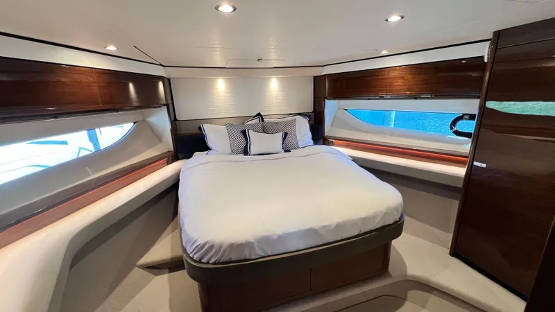  Yacht Photos Pics Luxurious bedroom interior of 2019 Princess F62 yacht with elegant wood finishes.